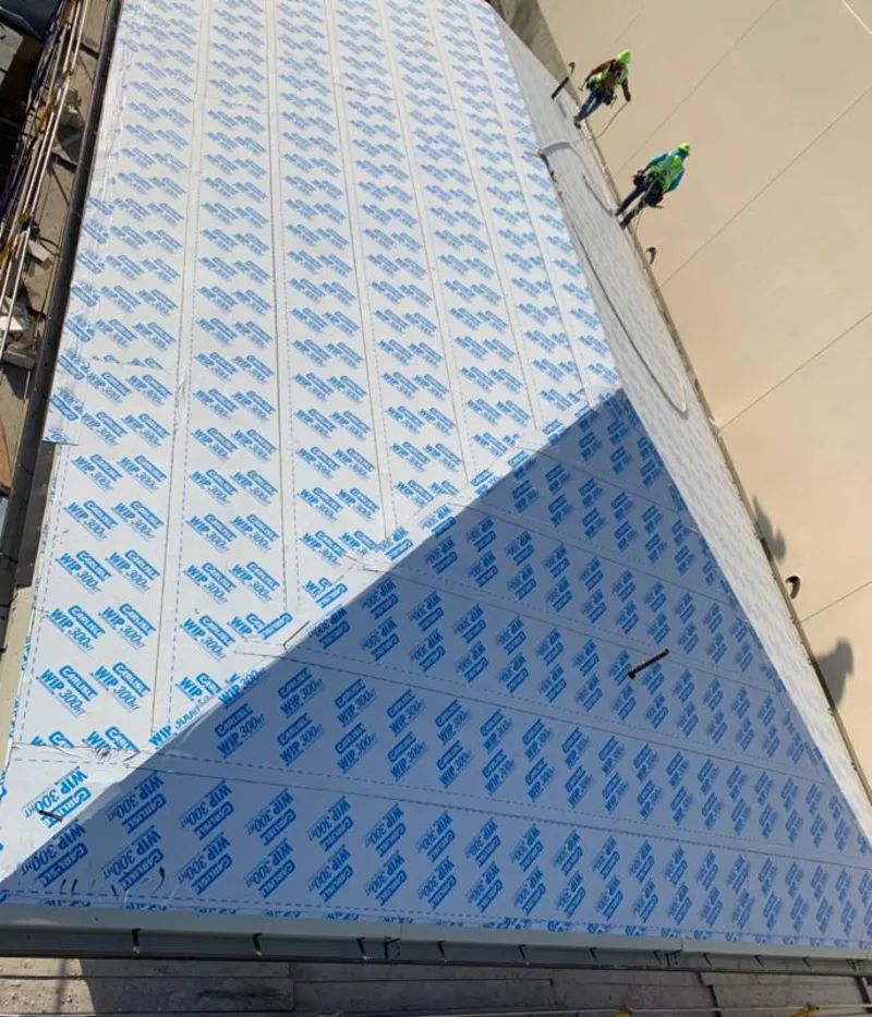 Professional roofers installing underlayment on a metal roof in Boston